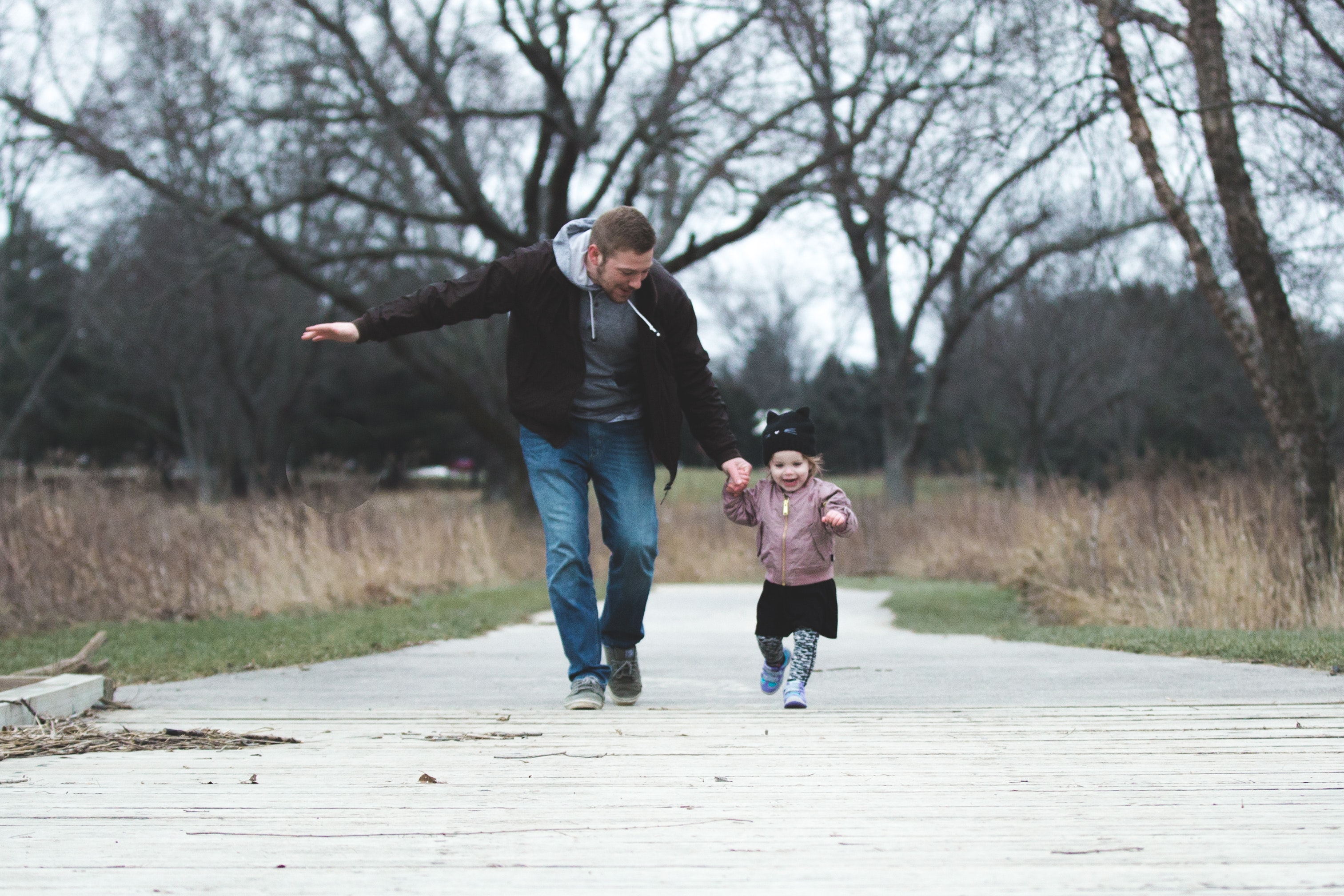 photo of father and daughter running at the park 853408