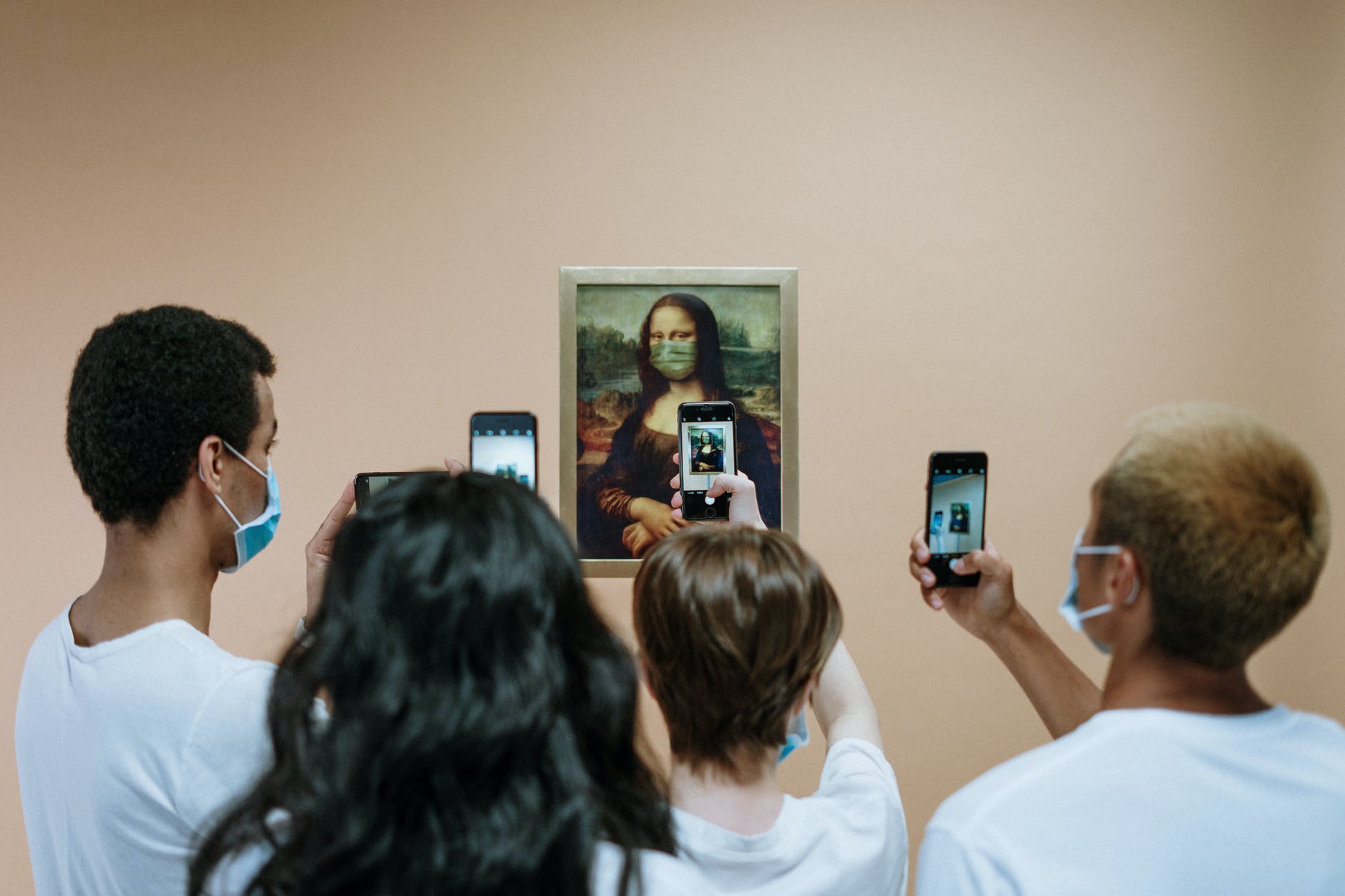 people taking picture of a painting of mona lisa with face mask | All 480,000 Works from The Louvre Have Gone Virtual