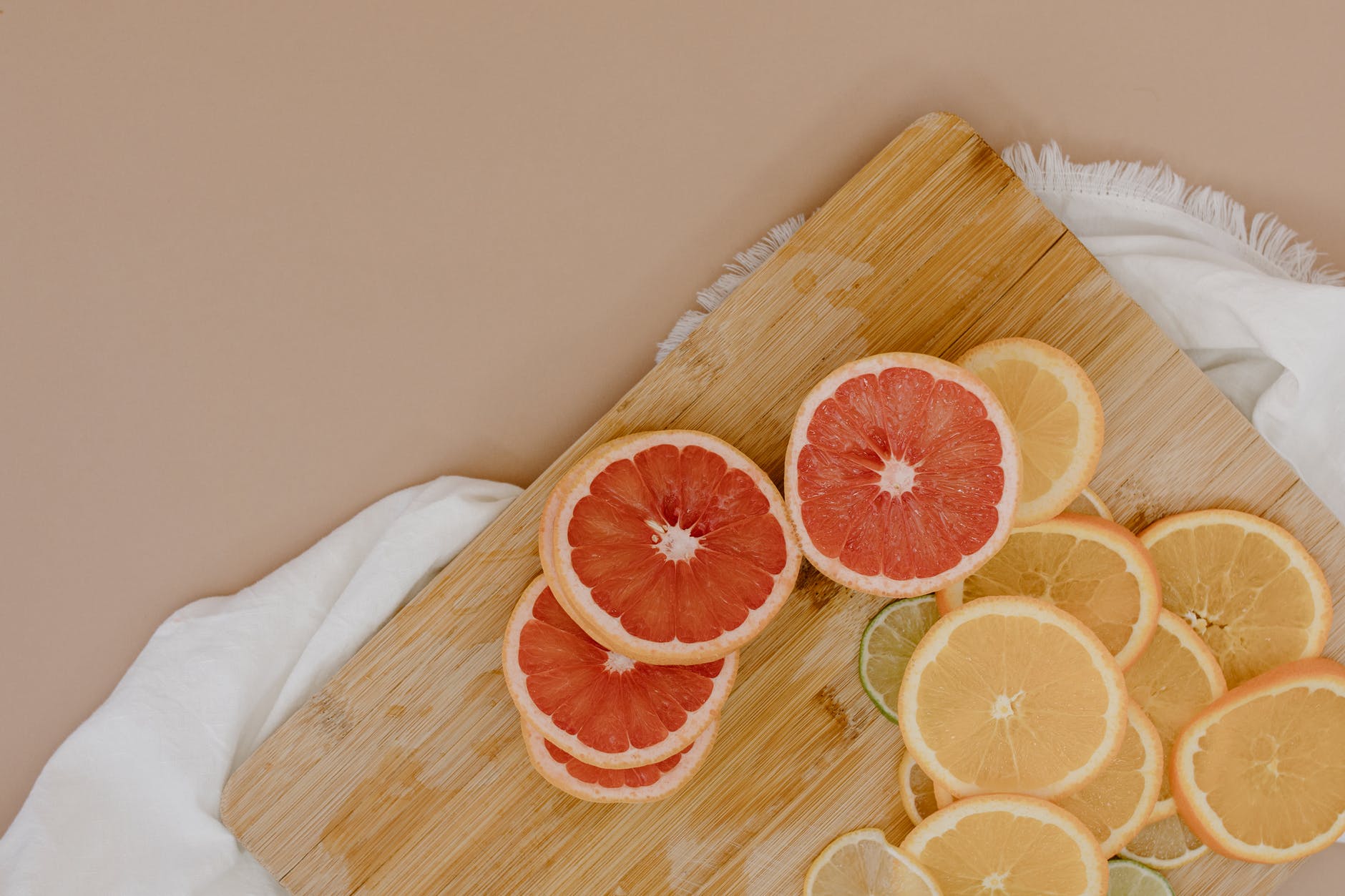 cutting board with sliced citrus fruits on napkin