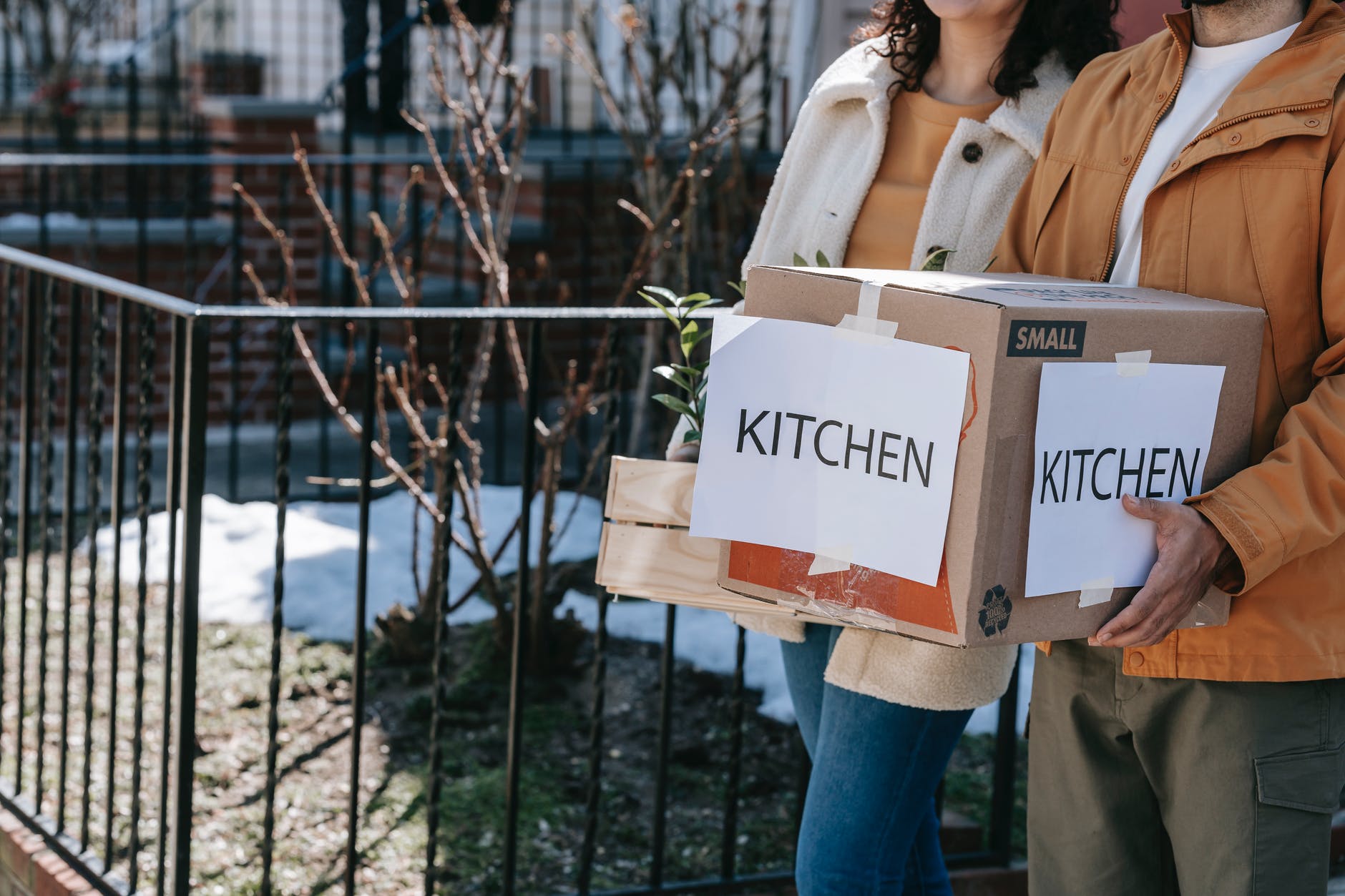 crop photo of man carrying packed kitchen wares in box