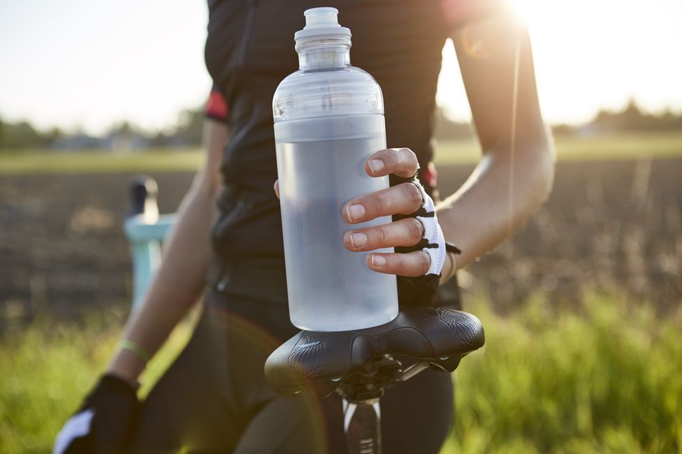 female cyclist holding water bottle mid section royalty free image 1622662545