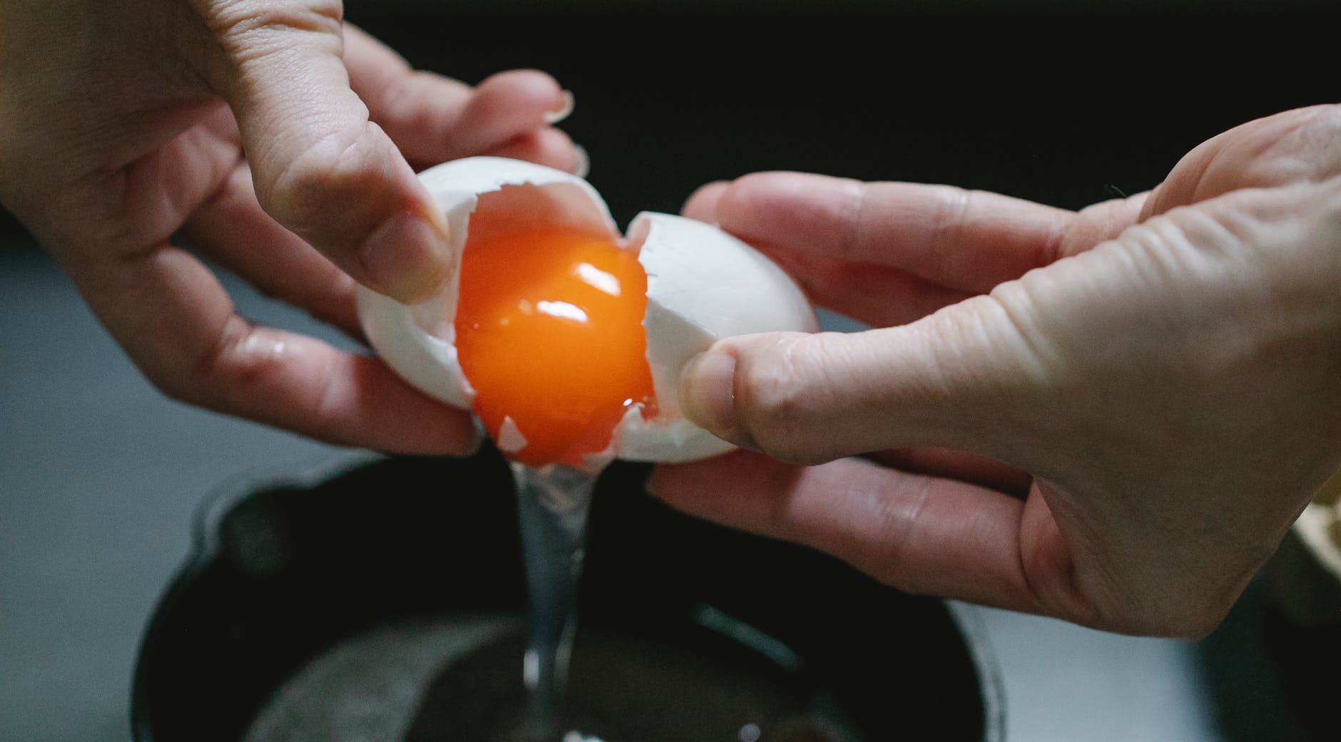 female cooking fried egg in pan