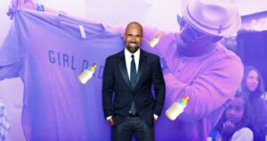 Shemar Moore in a suit with a background of the actor holding up a shirt with his baby's gender