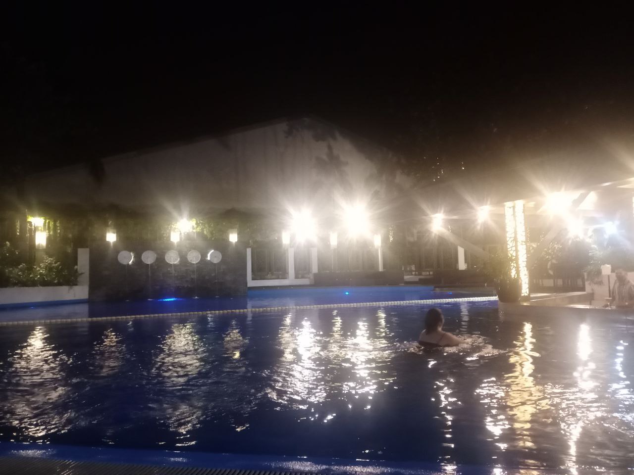 The Manila Hotel swimming pool at night, with the author swimming